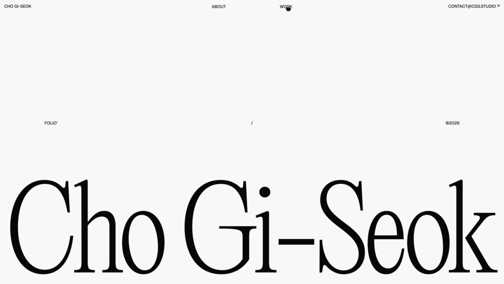 Page d'accueil minimaliste sur fond blanc. Le nom de l'artiste, Cho Gi-Seok, est écrit en lettres noires imposantes occupant la moitié inférieure de l'écran. En haut, un menu discret propose les sections About, Work et Contact, avec la mention Folio et l'année 2026.
