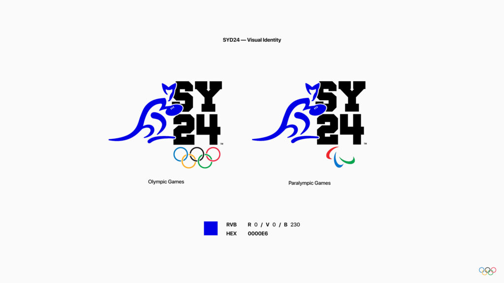 Présentation des logos SYD24 pour les Jeux Olympiques et Paralympiques sur fond blanc. Chaque logo combine un kangourou stylisé bleu en mouvement avec l'inscription « SY24 » en noir. En bas, les codes couleurs (RVB et HEX) du bleu utilisé sont précisés à côté d'un échantillon coloré.