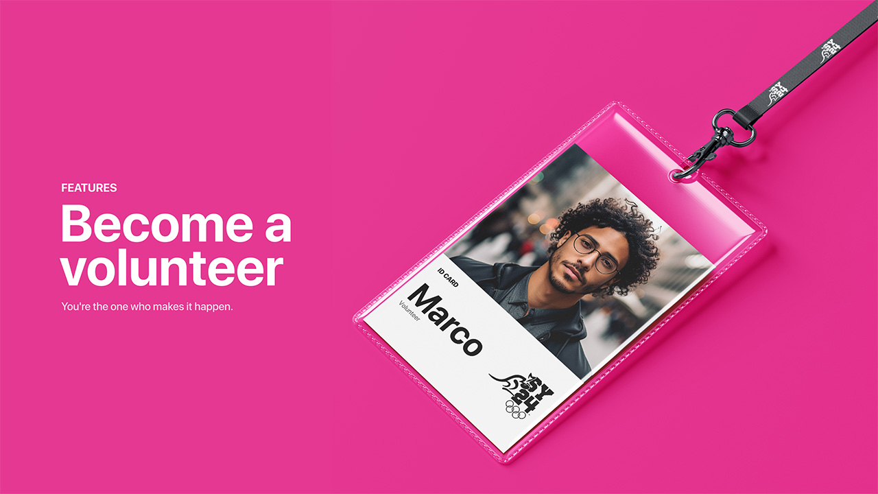 Visuel sur fond rose vif présentant le texte « Devenez volontaire » et le slogan « C'est vous qui rendez cela possible ». À droite, un badge d'accréditation transparent contient la photo d'un volontaire nommé Marco, accompagné du logo SYD24. Le badge est attaché à un cordon noir marqué du même logo.